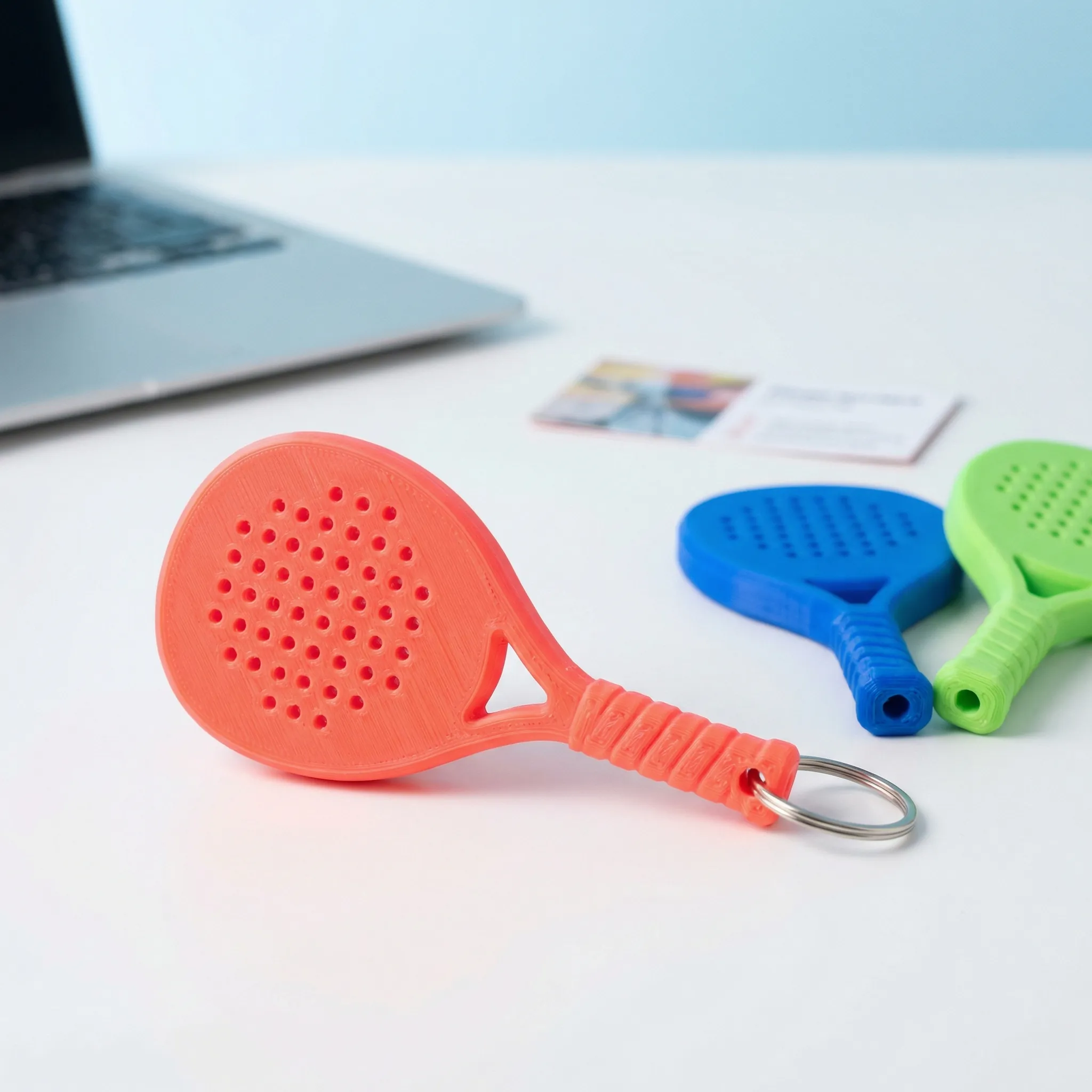 3D printed padel racket keychain displayed on a desk