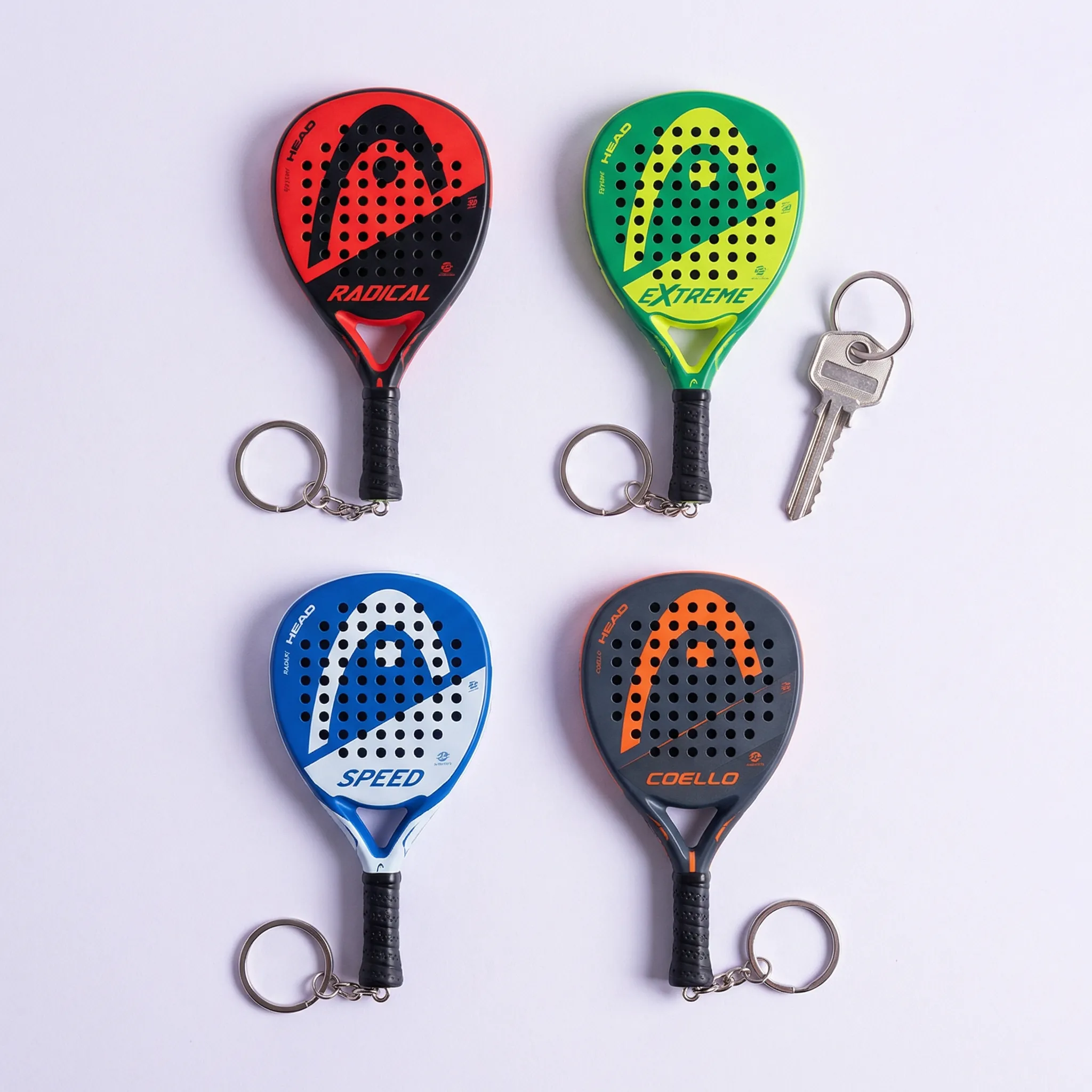 Hand holding a tiny HEAD padel racket keyring replica
