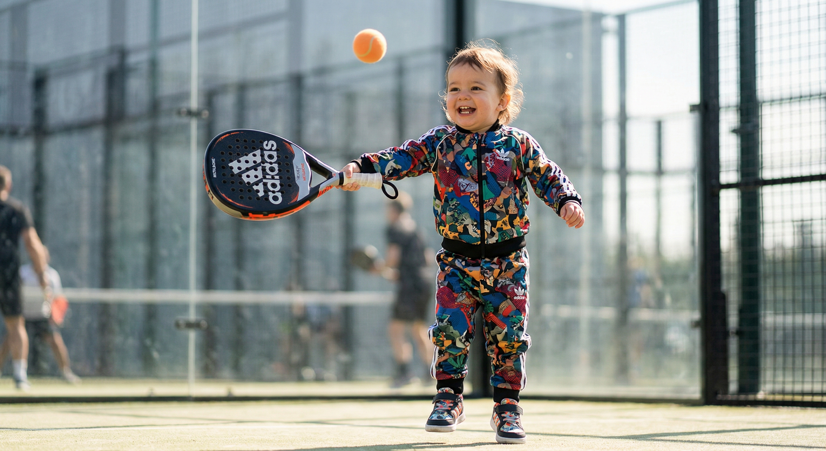 Toddler being served a mini padel racket gift